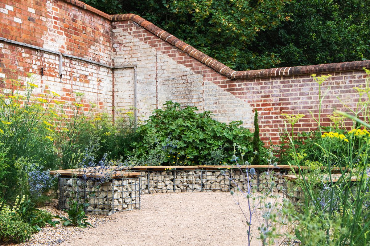A quiet seating area with a curved bench surrounded by plants and greenery at the University of Reading.