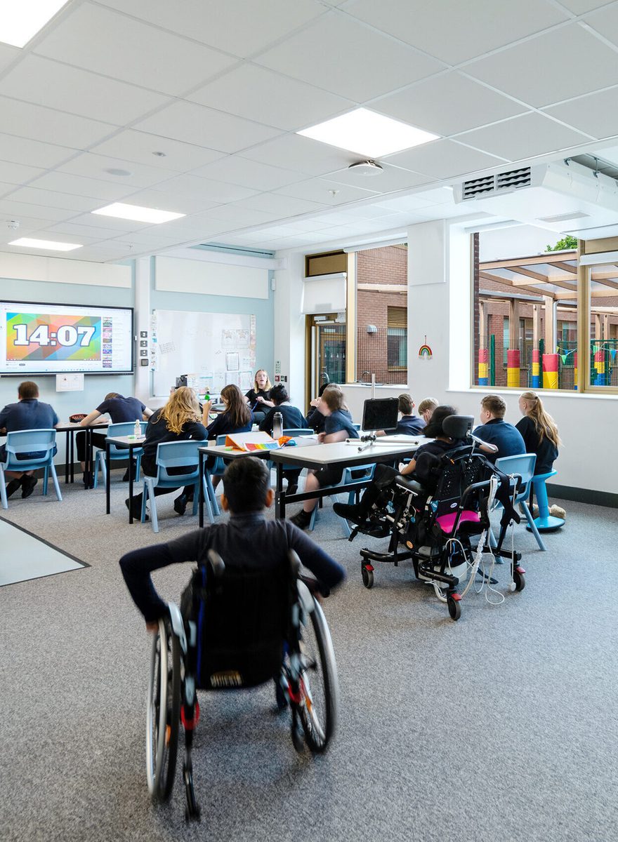 A portrait internal shot of one of the classrooms inside Pear Tree SEND School with plentiful natural light and students engaged in a lesson.