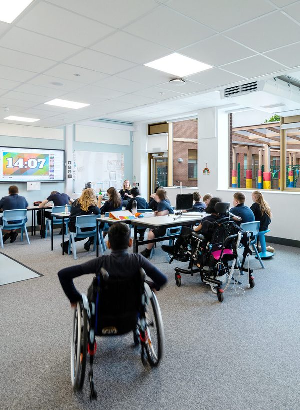 A portrait internal shot of one of the classrooms inside Pear Tree SEND School with plentiful natural light and students engaged in a lesson.