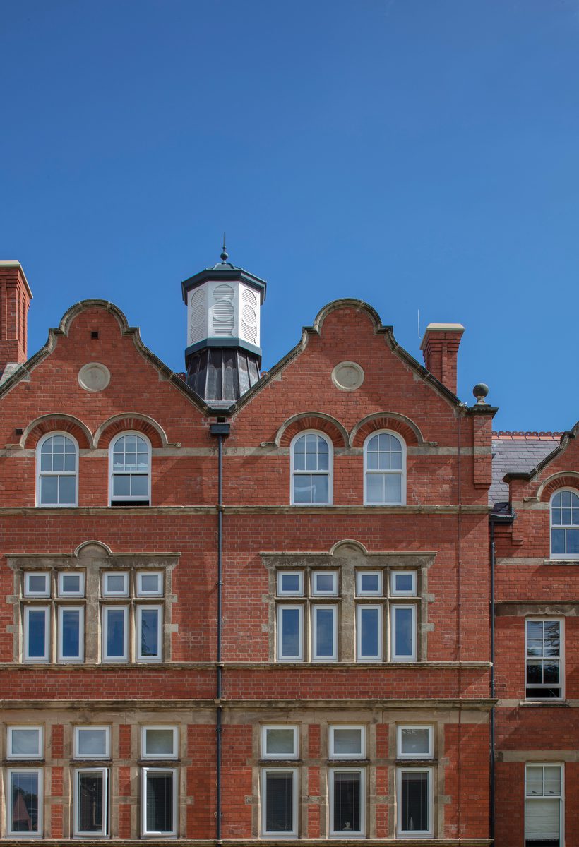 A detail shot of the red brick facade, window detailing and roof of Radbrook Hall, a Grade II listed building retained and adapted as part of Radbrook Village.