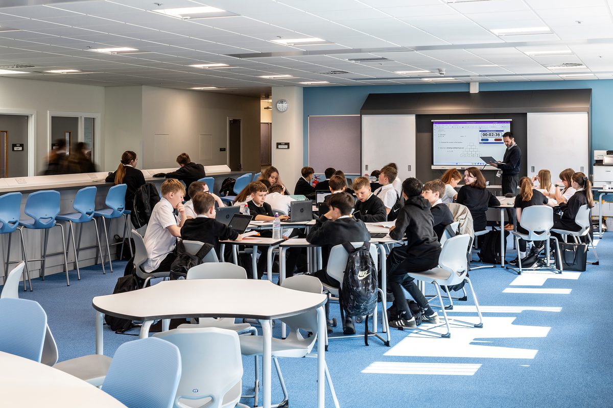 Pupils working in a variety of different workspaces within a classroom in the Woodmill and St Columba's RC High School.