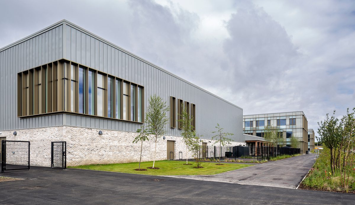 The exterior wall of the Woodmill and St Columba's RC High School, showing the large scale of the school, and landscaped planting surrounding the school.