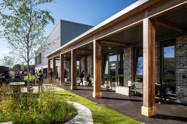 Pupils enjoying the landscaped outdoor spaces within the the Woodmill and St Columba's RC High School campus, with highly landscaped planting and a variety of seating options, with some under shelter.