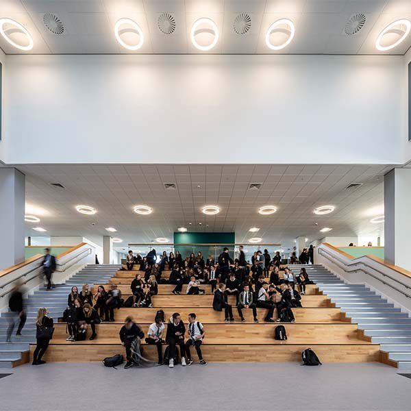 Pupils sitting on the Spanish Steps in the centre of the dining hall of the Woodmill and St Columba's RC High School.