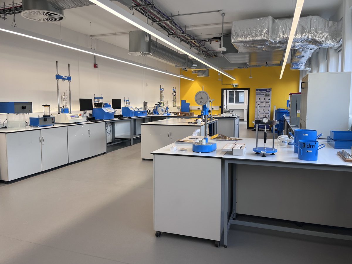 The state of the art interior of the newly refurbished Robert Blackburn Laboratory, with specialist engineering equipment and bright yellow wall.