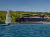The Waterfront cafe at Rother Valley Country Park situated next to a large lake with a sail boat in the foreground.