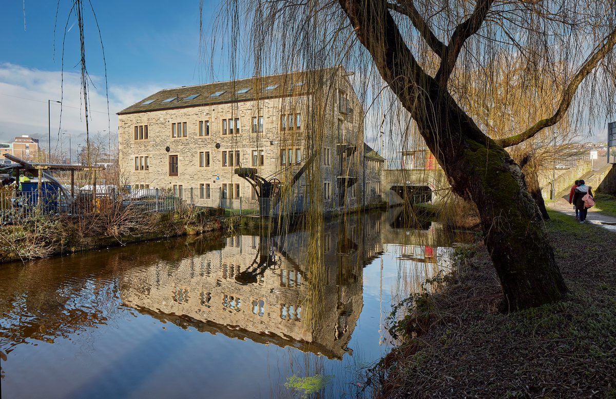 A historic exterior of the grade II listed canal warehouse showing its waterfront location.