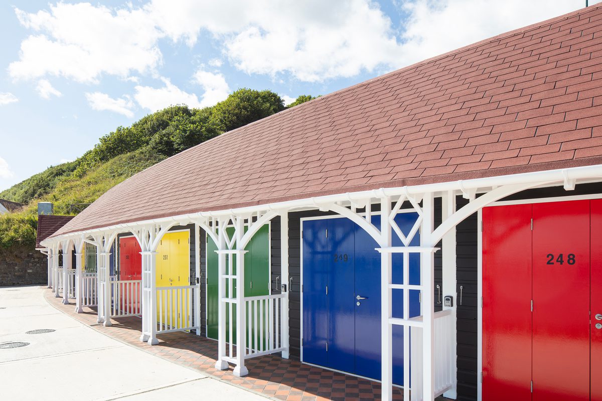 A row rebuilt colourful beach chalets on Scarborough's South Cliff, showing decorative wooden features.