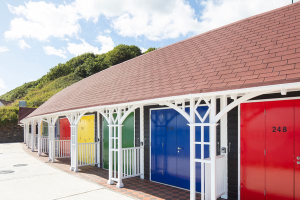 A row rebuilt colourful beach chalets on Scarborough's South Cliff, showing decorative wooden features.