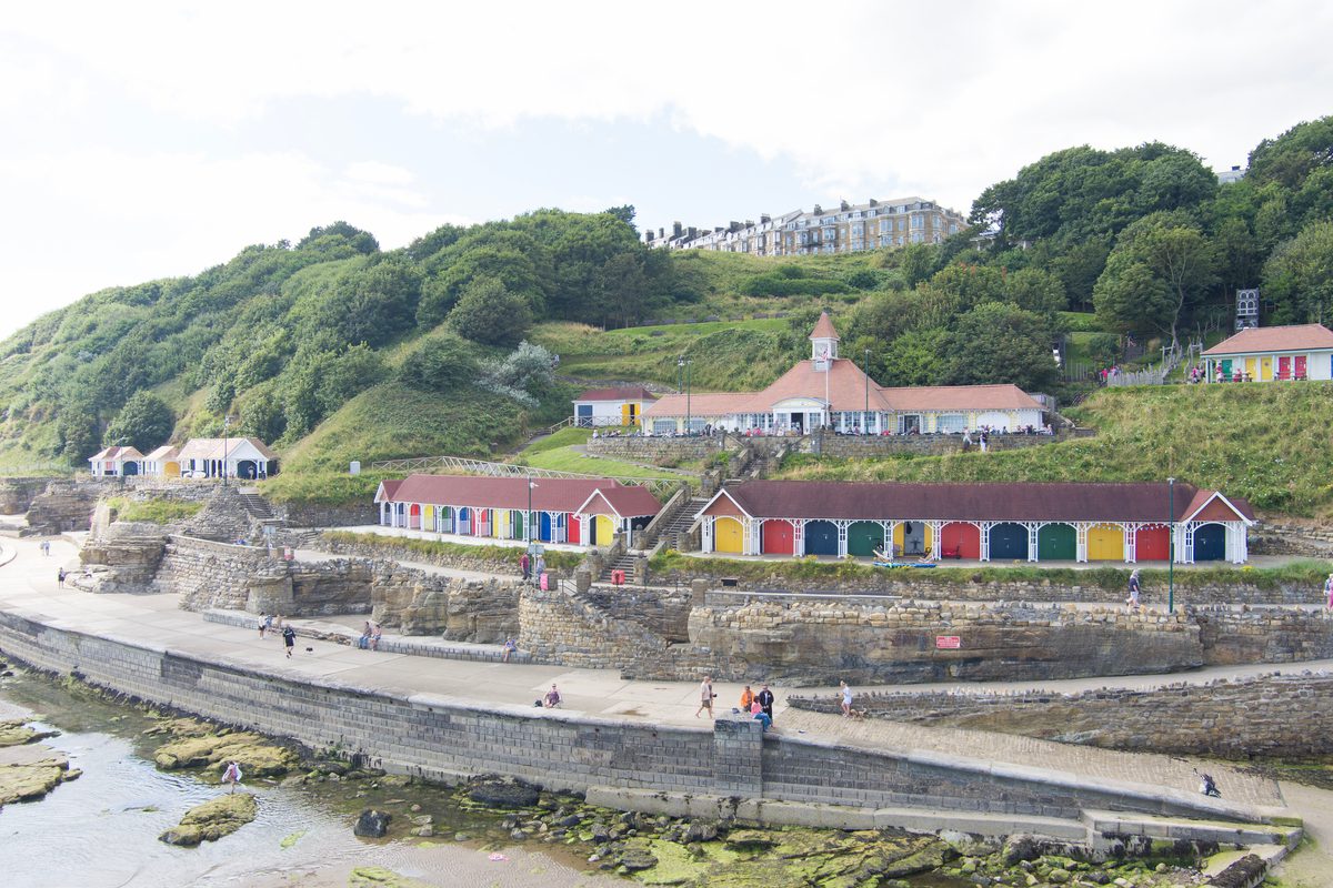 The row of chalets on Scarborough's South Cliff, taken from afar, showing their cliffside and beach front location.