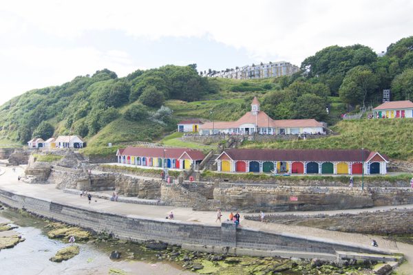 The row of chalets on Scarborough's South Cliff, taken from afar, showing their cliffside and beach front location.