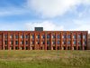 Elevation of the Stafford Barracks on a bright, sunny day with green grass in the foreground.