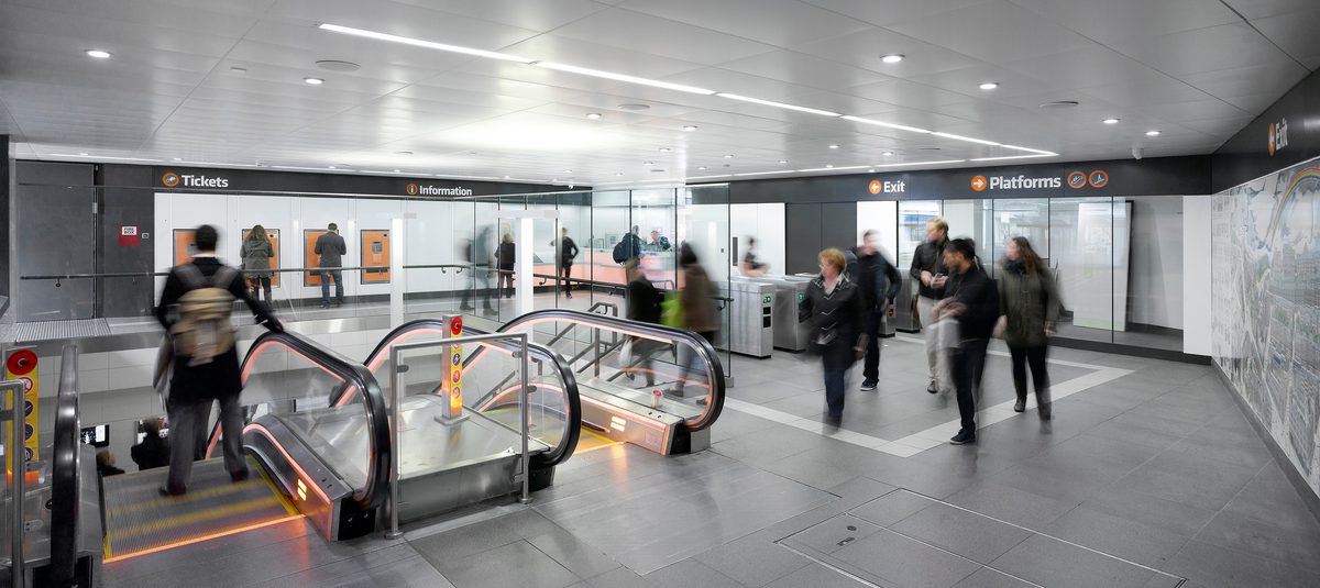 Interior view of the refurbished Glasgow subway station entrance hall with new escalators, ticket systems and signage.