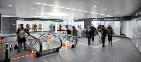 Interior view of the refurbished Glasgow subway station entrance hall with new escalators, ticket systems and signage.