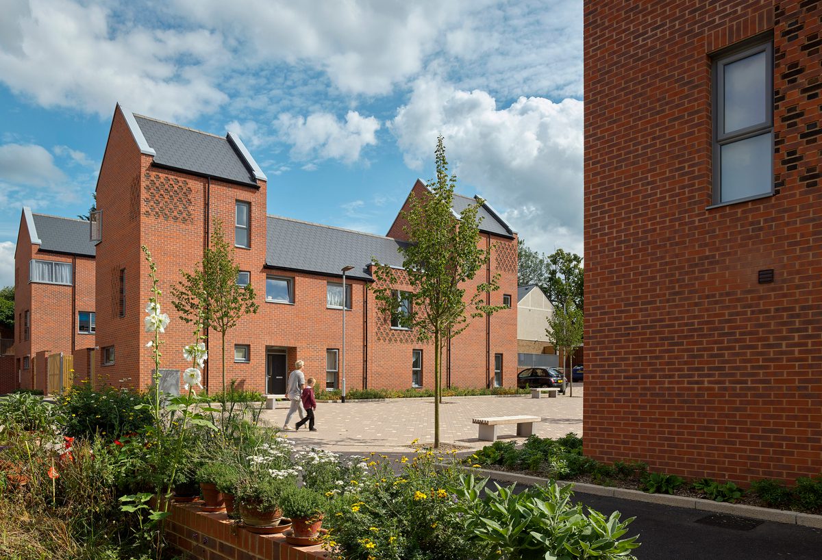 The residential scheme The Ridgeway on a sunny day with planting and trees in the foreground.