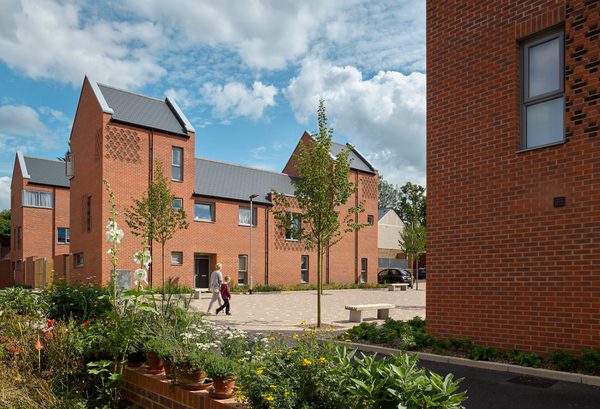 The residential scheme The Ridgeway on a sunny day with planting and trees in the foreground.
