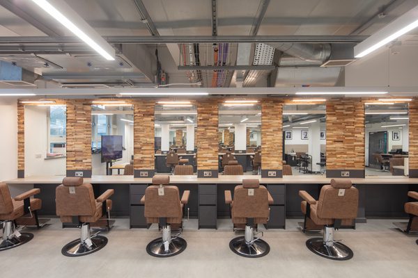 A row of hair dresser chairs, stations and mirrors showing real world application inside the Sheffield College's City Campus.