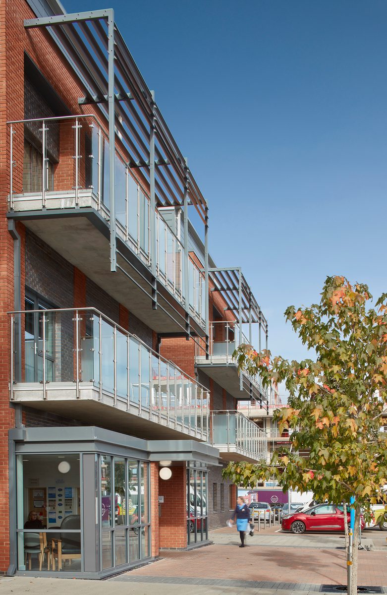 The redbrick exterior of Townlands Community Hospital with glass fronted reception and covered balconies on the first and second floors.