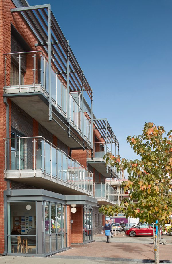 The redbrick exterior of Townlands Community Hospital with glass fronted reception and covered balconies on the first and second floors.