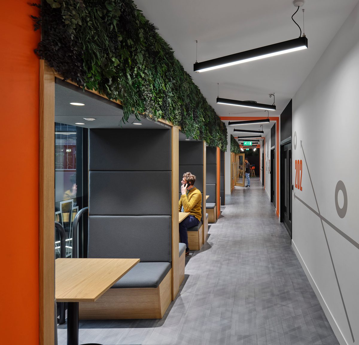 Corridor at University Academy 92 (UA92) showing breakout seating area, living wall feature and contemporary lighting.