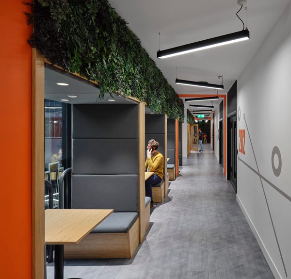 Corridor at University Academy 92 (UA92) showing breakout seating area, living wall feature and contemporary lighting.
