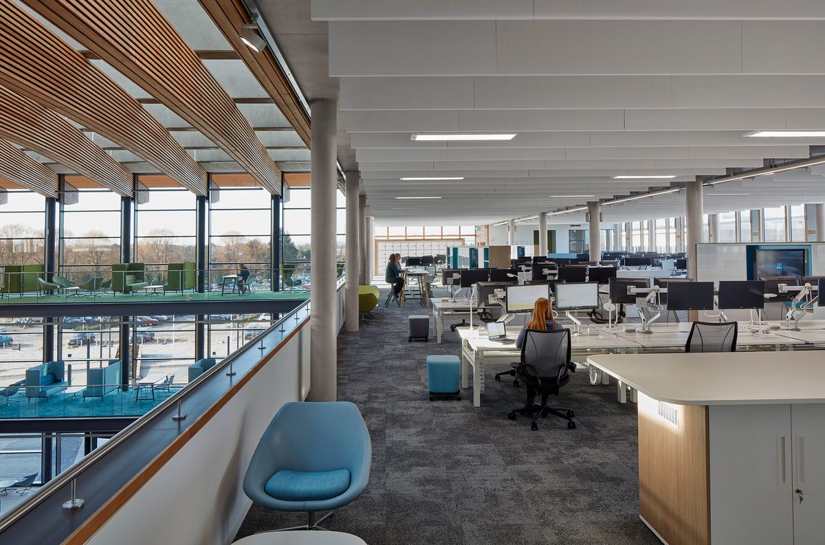 People using the communal office space adjacent to the large atrium in the UK Hydrographic Office.