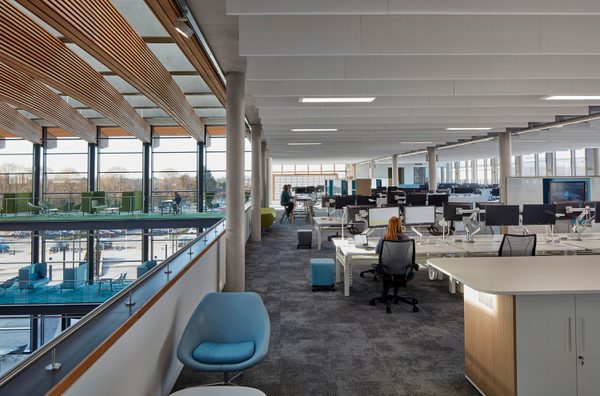 People using the communal office space adjacent to the large atrium in the UK Hydrographic Office.