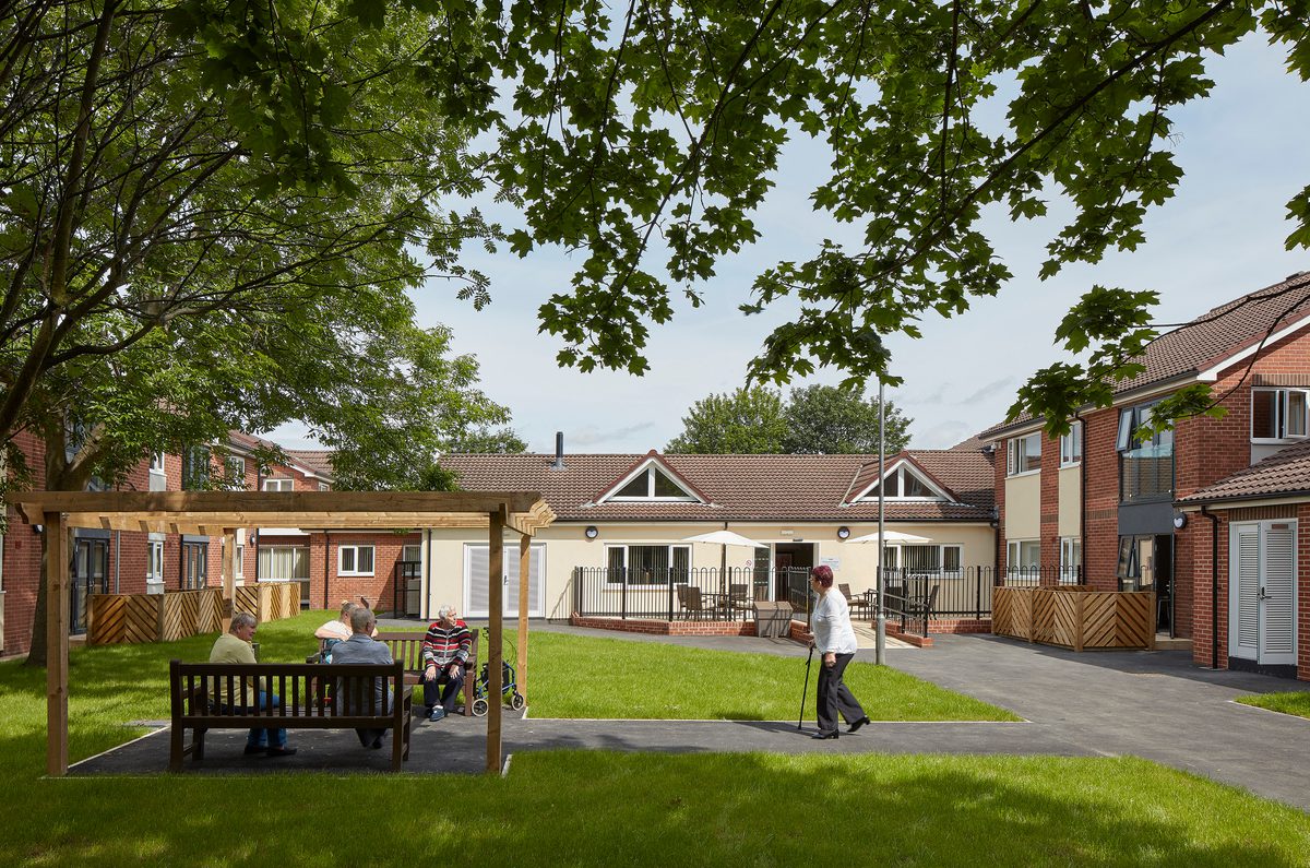 Residents enjoying the communal gardens with housing surrounding in Wakefield as part of the Vico Homes scheme.