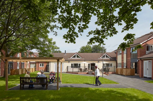 Residents enjoying the communal gardens with housing surrounding in Wakefield as part of the Vico Homes scheme.