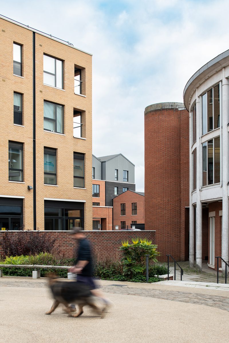 A residential block within the Victoria Square development, with a pedestrian walking their dog in the newly created public realm.