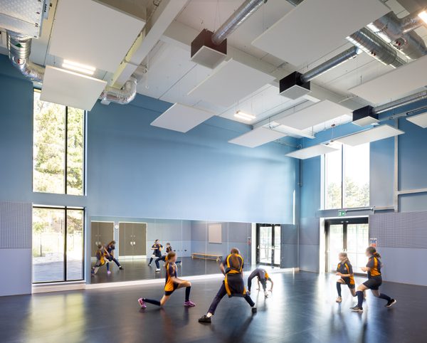 Students using the bright sports hall within the Winterstoke Hundred Academy, with double height windows.